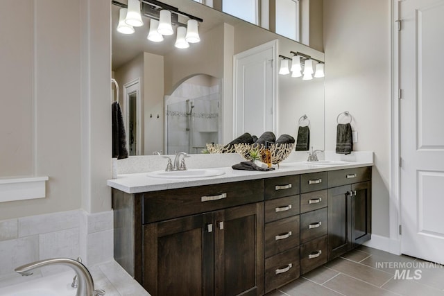 bathroom with plus walk in shower, tile patterned flooring, and vanity