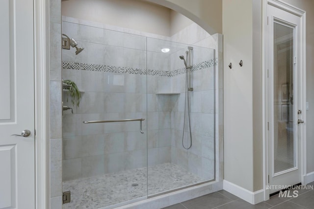 bathroom featuring a shower with shower door and tile patterned floors