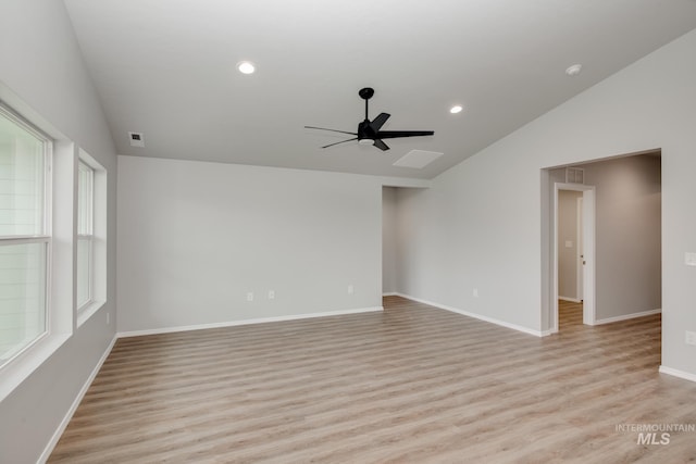 spare room featuring ceiling fan, lofted ceiling, and light wood-type flooring