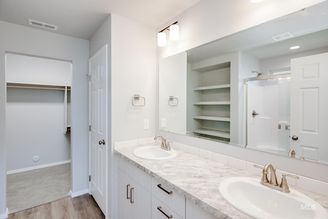 bathroom featuring walk in shower, wood-type flooring, built in features, and vanity