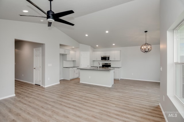 unfurnished living room featuring ceiling fan with notable chandelier, lofted ceiling, light hardwood / wood-style floors, and sink