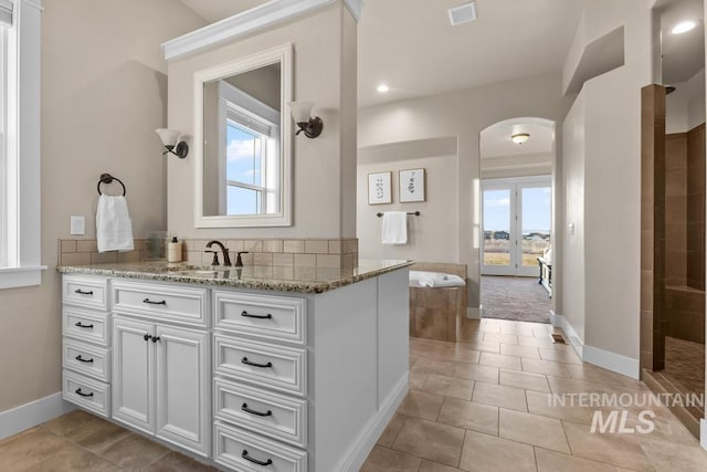 bathroom featuring vanity, a healthy amount of sunlight, visible vents, and tile patterned flooring