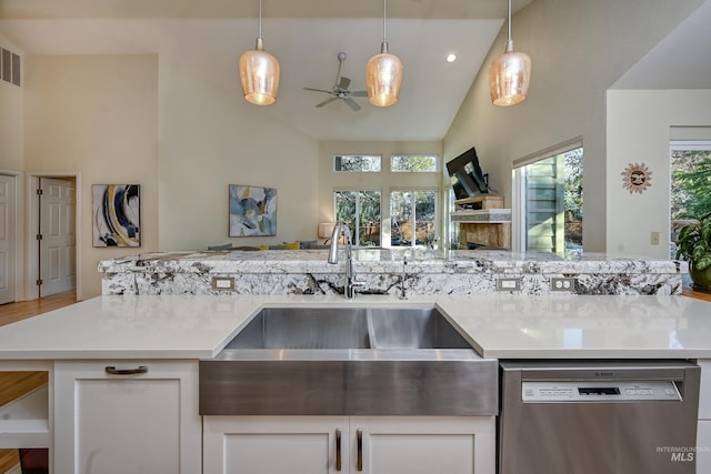 kitchen featuring dishwasher, a sink, a ceiling fan, open floor plan, and decorative light fixtures