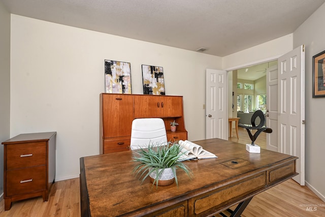home office with light wood finished floors and baseboards