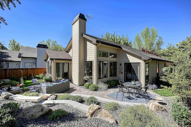 rear view of property with a patio area, fence, and a chimney