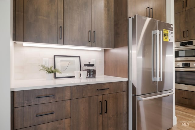 24910 Ardmore Ct, Caldwell, ID 83607 - kitchen featuring stainless steel appliances, modern cabinets, backsplash, light countertops, and light wood-type flooring