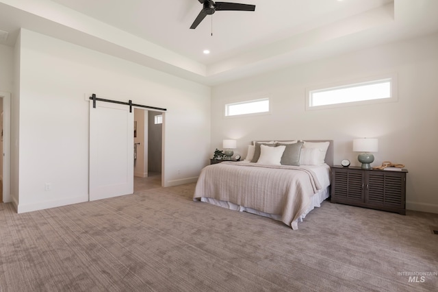 24910 Ardmore Ct, Caldwell, ID 83607 - bedroom with a barn door, carpet, a tray ceiling, baseboards, and a ceiling fan