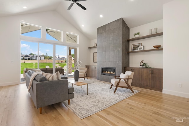 24910 Ardmore Ct, Caldwell, ID 83607 - living area with a ceiling fan, light wood-style floors, a tile fireplace, high vaulted ceiling, and baseboards