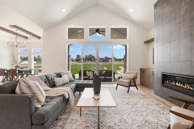 24910 Ardmore Ct, Caldwell, ID 83607 - living area featuring light wood-style floors, a chandelier, high vaulted ceiling, a tile fireplace, and recessed lighting