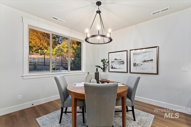 dining space featuring hardwood / wood-style floors and a notable chandelier