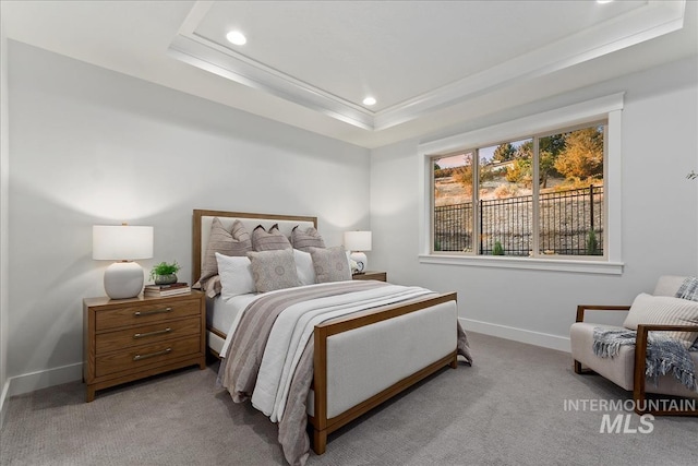 carpeted bedroom featuring a raised ceiling