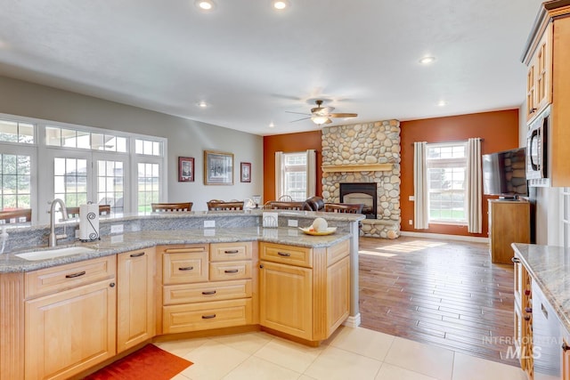 1795 W Black Canyon Hwy, Emmett, ID 83617 - kitchen with a sink, light brown cabinets, ceiling fan, and a fireplace
