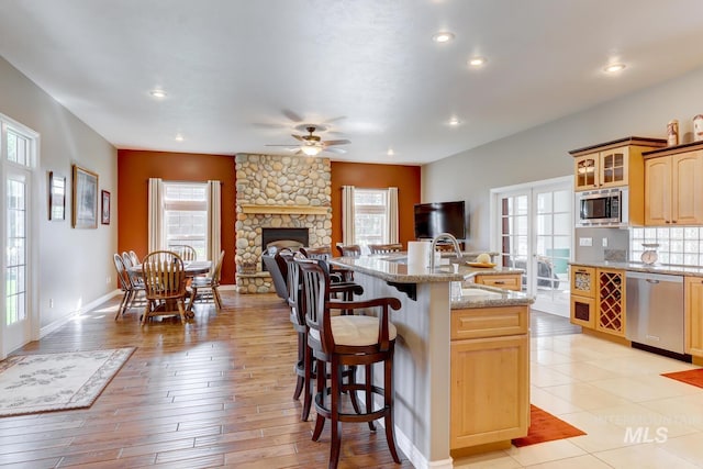 1795 W Black Canyon Hwy, Emmett, ID 83617 - kitchen with a ceiling fan, a center island with sink, a sink, a breakfast bar, and stainless steel appliances
