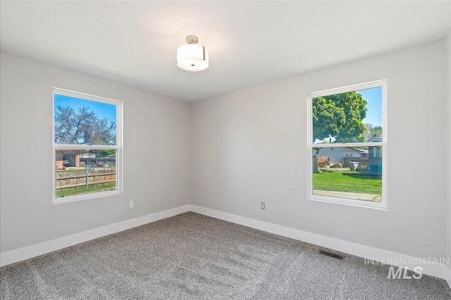 empty room featuring baseboards, carpet, and visible vents