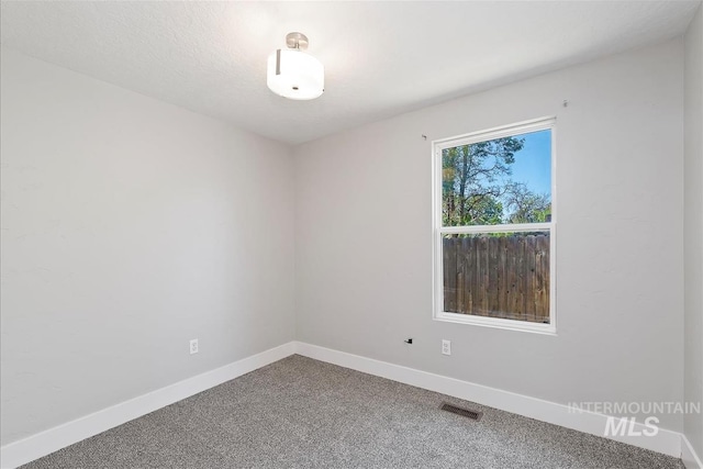spare room featuring visible vents, baseboards, and carpet floors