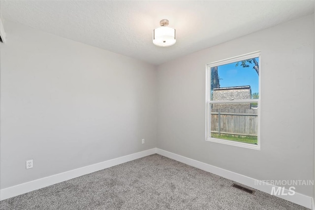 unfurnished room featuring baseboards, carpet, and visible vents