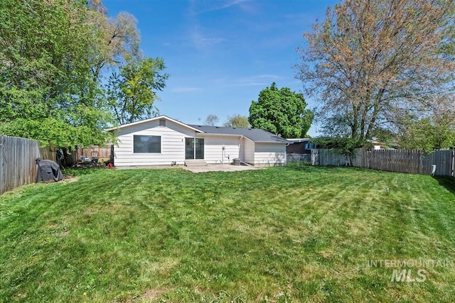 back of house with a fenced backyard, a yard, and a patio area