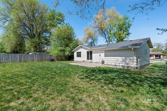 rear view of house with a fenced backyard, a patio area, and a yard