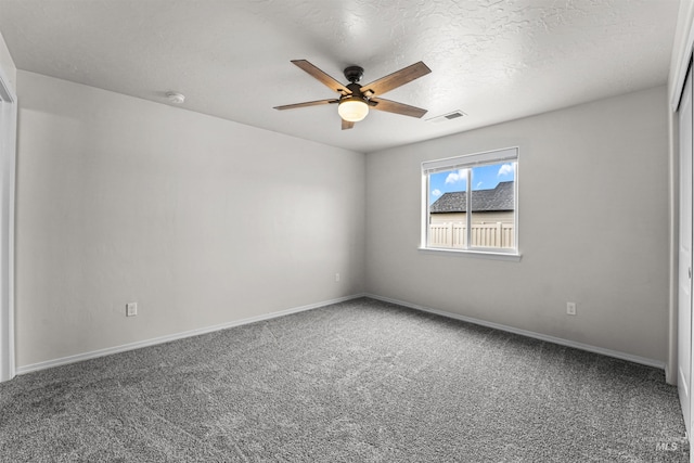 carpeted spare room with ceiling fan and baseboards