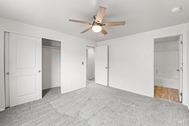 unfurnished bedroom featuring carpet flooring, a closet, ensuite bathroom, and baseboards