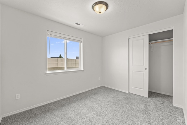unfurnished bedroom with carpet flooring, baseboards, and a closet
