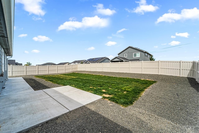 view of yard featuring a fenced backyard, a residential view, and a patio