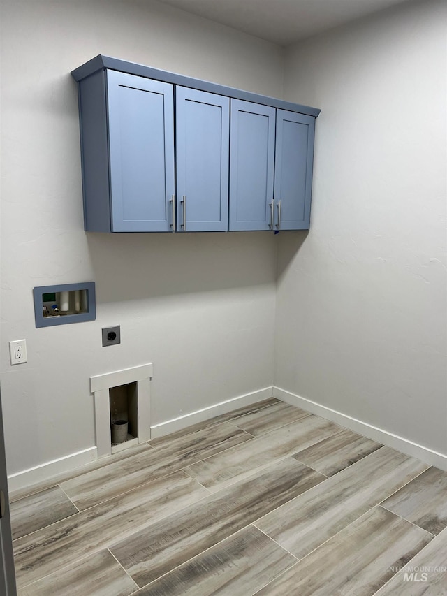 clothes washing area featuring light hardwood / wood-style floors, electric dryer hookup, cabinets, and washer hookup