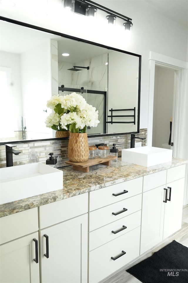 bathroom with walk in shower, tasteful backsplash, vanity, and hardwood / wood-style floors