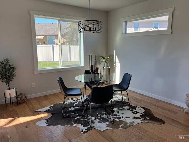 dining area with hardwood / wood-style flooring and an inviting chandelier