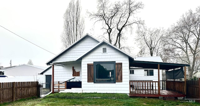 back of house featuring a lawn and a deck