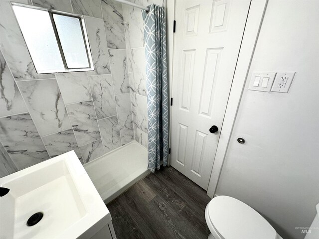 bathroom with a shower with curtain, sink, hardwood / wood-style floors, and toilet