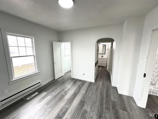 unfurnished bedroom featuring dark hardwood / wood-style flooring and baseboard heating