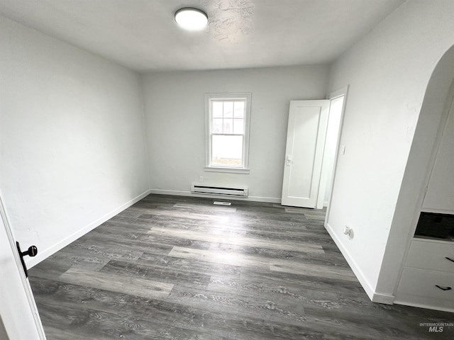 spare room with dark hardwood / wood-style floors and a baseboard radiator