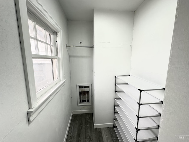 walk in closet with dark wood-type flooring and heating unit