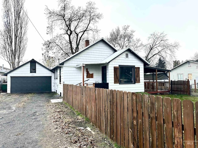 bungalow with a garage and an outbuilding