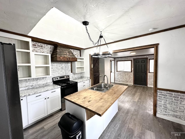 kitchen featuring custom exhaust hood, a center island with sink, sink, electric range, and decorative light fixtures