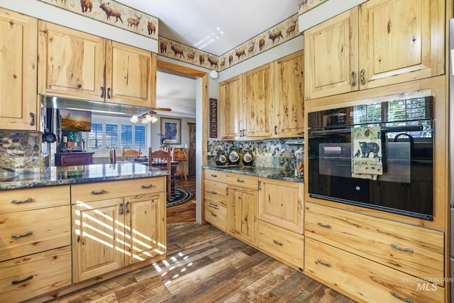 kitchen featuring dark stone countertops, light brown cabinetry, backsplash, and dark hardwood / wood-style floors