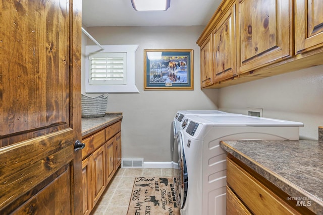 clothes washing area with cabinets, independent washer and dryer, and light tile patterned floors