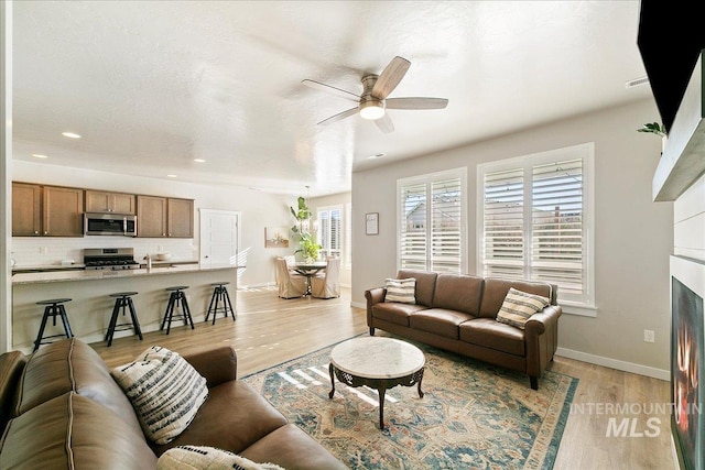 living room with ceiling fan and light hardwood / wood-style floors