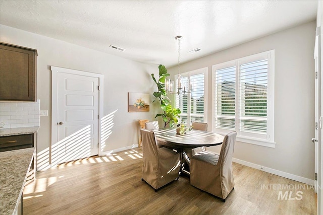 dining space with an inviting chandelier and light hardwood / wood-style floors