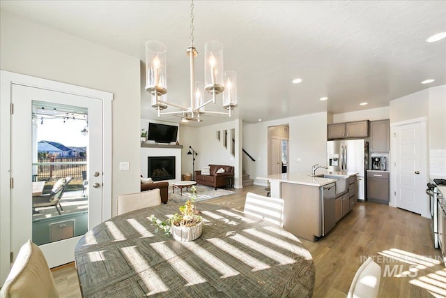 dining space with light hardwood / wood-style floors, sink, and a notable chandelier