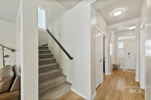 stairway with hardwood / wood-style floors and plenty of natural light