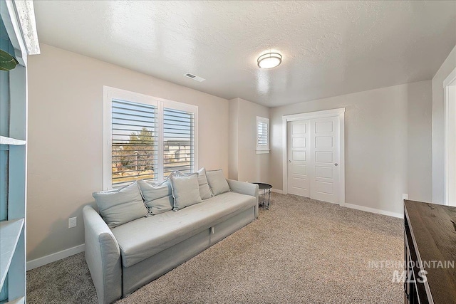 carpeted living room featuring a textured ceiling