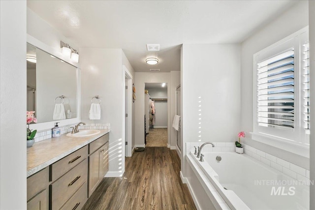 bathroom featuring a tub, hardwood / wood-style floors, and vanity