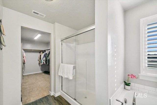 bathroom with hardwood / wood-style floors and shower with separate bathtub