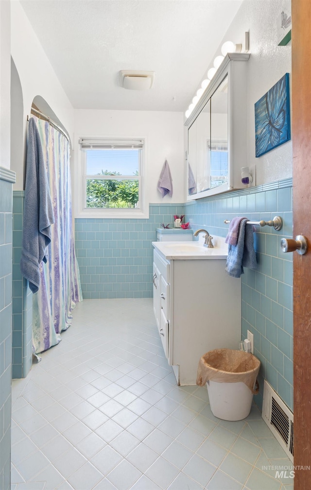 209 N Canyon St, Nampa, ID 83651 - full bathroom with tile patterned floors, tile walls, vanity, and a wainscoted wall