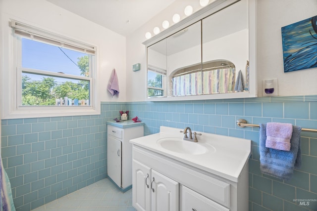 209 N Canyon St, Nampa, ID 83651 - full bathroom with tile walls, vanity, wainscoting, healthy amount of natural light, and tile patterned flooring