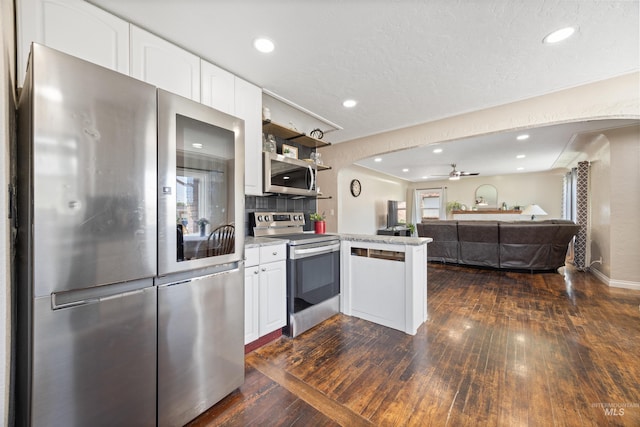 209 N Canyon St, Nampa, ID 83651 - kitchen with stainless steel appliances, dark wood finished floors, white cabinets, a peninsula, and open floor plan