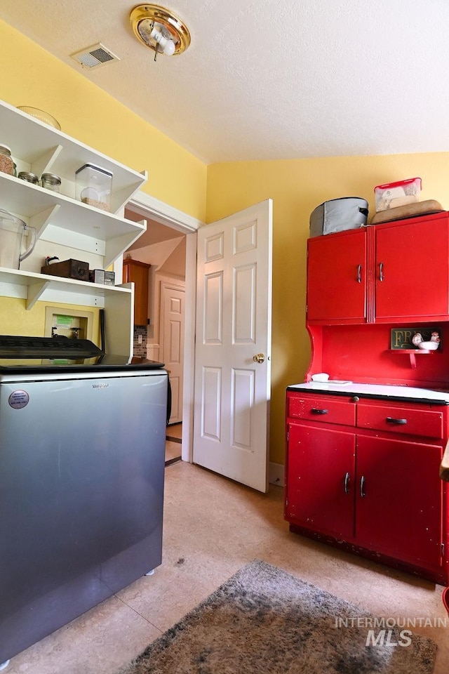 221 N Union St, Star, ID 83669 - kitchen with red cabinetry, refrigerator, and a textured ceiling