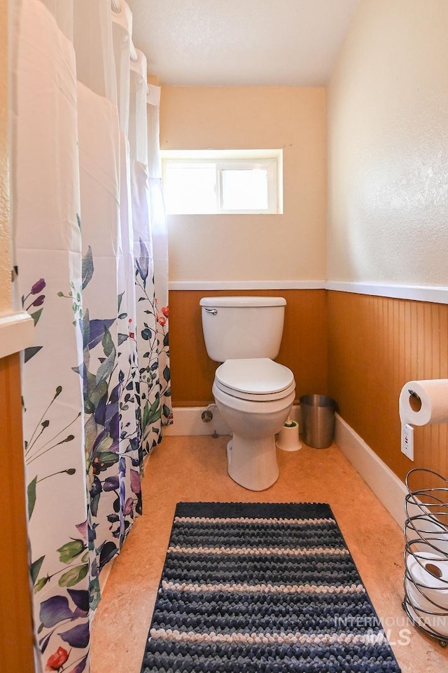 221 N Union St, Star, ID 83669 - bathroom featuring toilet, a wainscoted wall, and a shower with shower curtain